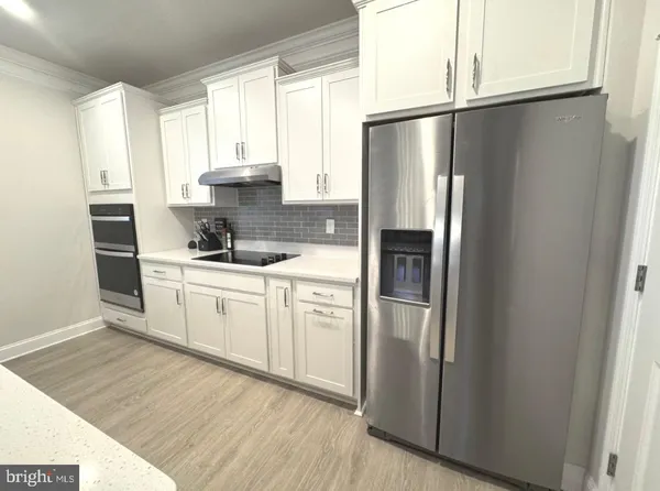 a dining hall with stainless steel appliances kitchen island granite countertop furniture and a large window
