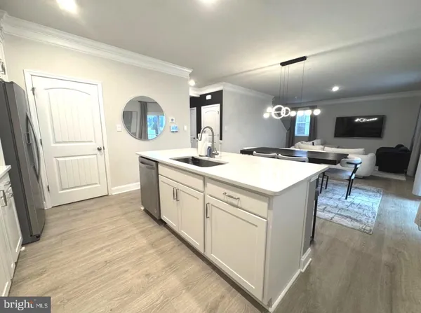 a large white kitchen with a sink and cabinets