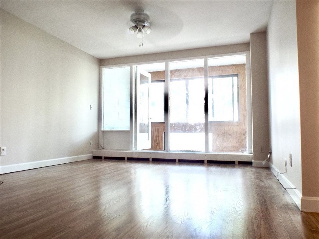 32 Juniper Street, Unit 98 Brookline, MA 02445 - Photo 6 of 17 a view of room with hardwood floor and window