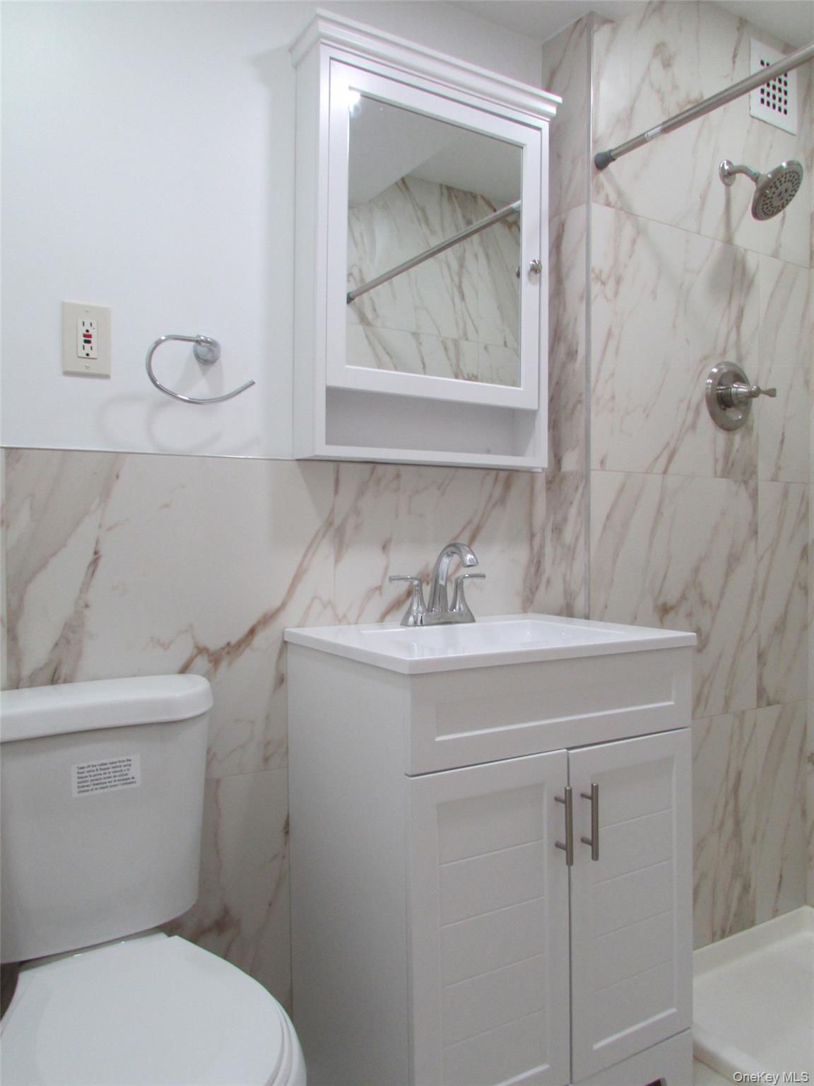 30 South Cole Avenue, Unit 6F Spring Valley, NY 10977 - Photo 15 of 30 a bathroom with a toilet a sink and mirror