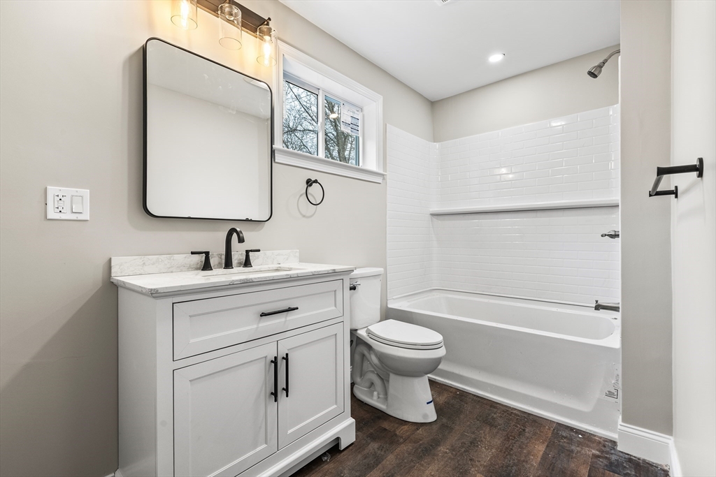 233 Central Street Foxboro, MA 02035 - Photo 11 of 16 a bathroom with a toilet sink a mirror a vanity and bathtub