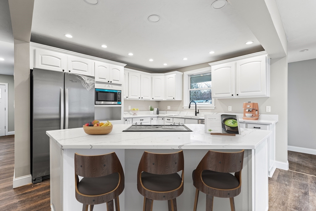 233 Central Street Foxboro, MA 02035 - Photo 2 of 16 a kitchen with kitchen island a stove a table and chairs