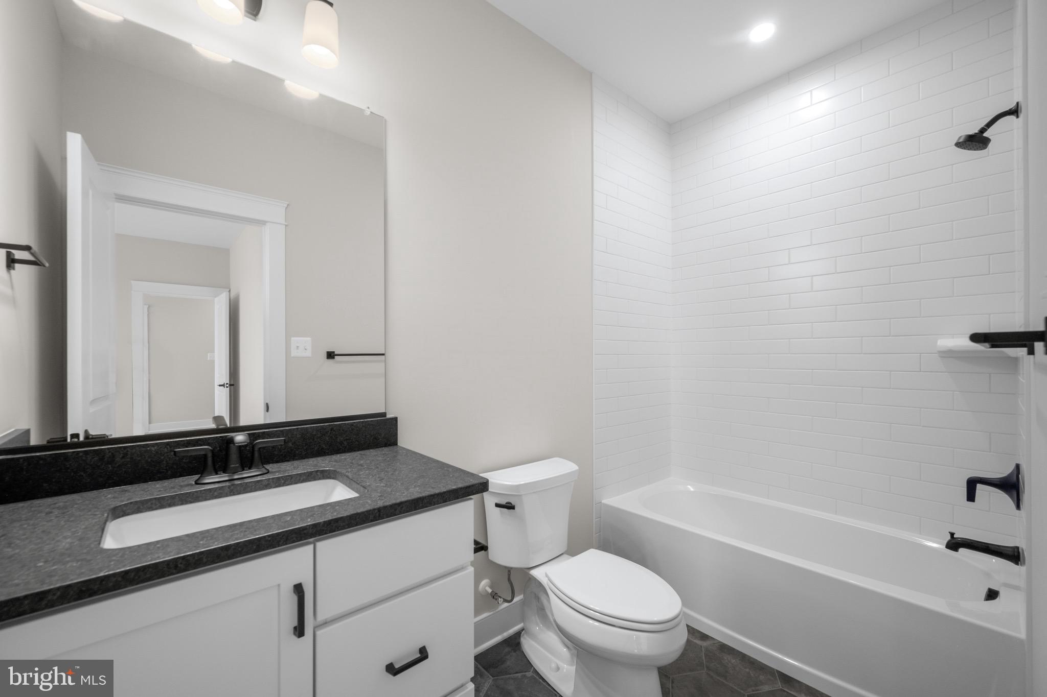 869 Morgan Station Road Woodbine, MD 21797 - Photo 35 of 38 a bathroom with a granite countertop sink a toilet and a bathtub