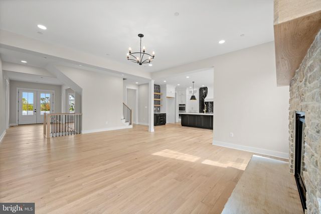 a view of an empty room with kitchen and window