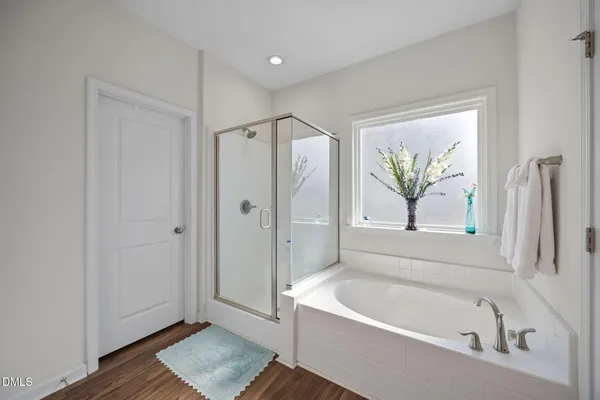 a bathroom with a tub a window and a shower