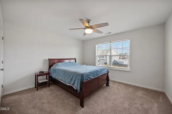 a spacious bedroom with a bed and a window