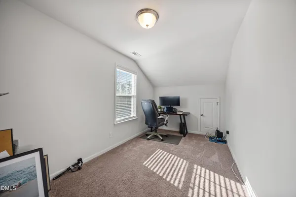 a view of a workspace with furniture and a window