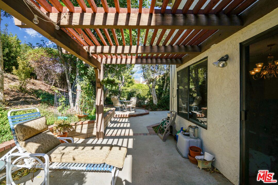 19401 Crystal Ridge Lane Porter Ranch, CA 91326 - Photo 25 of 45 a view of a patio with table and chairs potted plants with floor to ceiling window