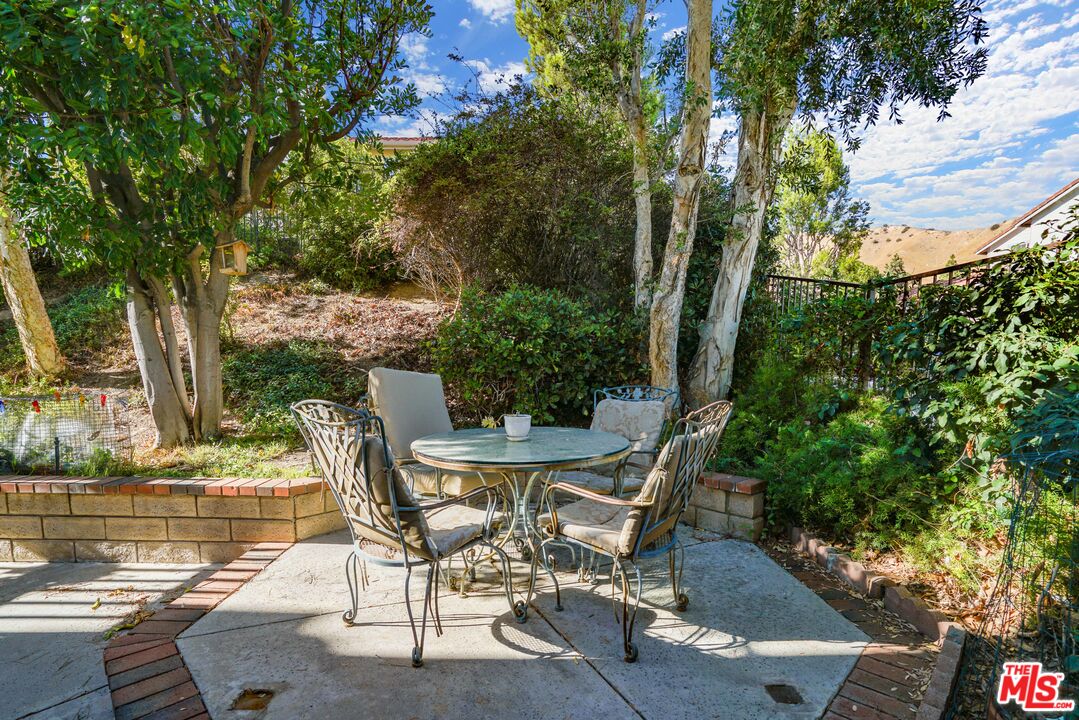 19401 Crystal Ridge Lane Porter Ranch, CA 91326 - Photo 27 of 45 a view of backyard with seating space and trees in the background