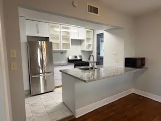 a kitchen with stainless steel appliances granite countertop a refrigerator sink and stove