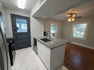 a kitchen with a sink a faucet cabinets and a window