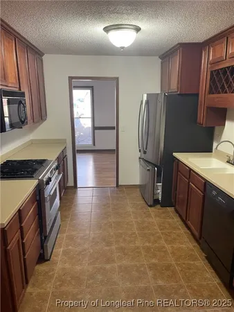 a kitchen with stainless steel appliances granite countertop a refrigerator and a stove