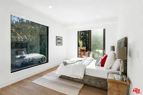 a bedroom with a bed and large window