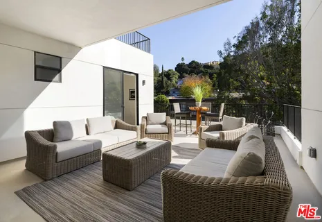 a outdoor living room with furniture and a large window