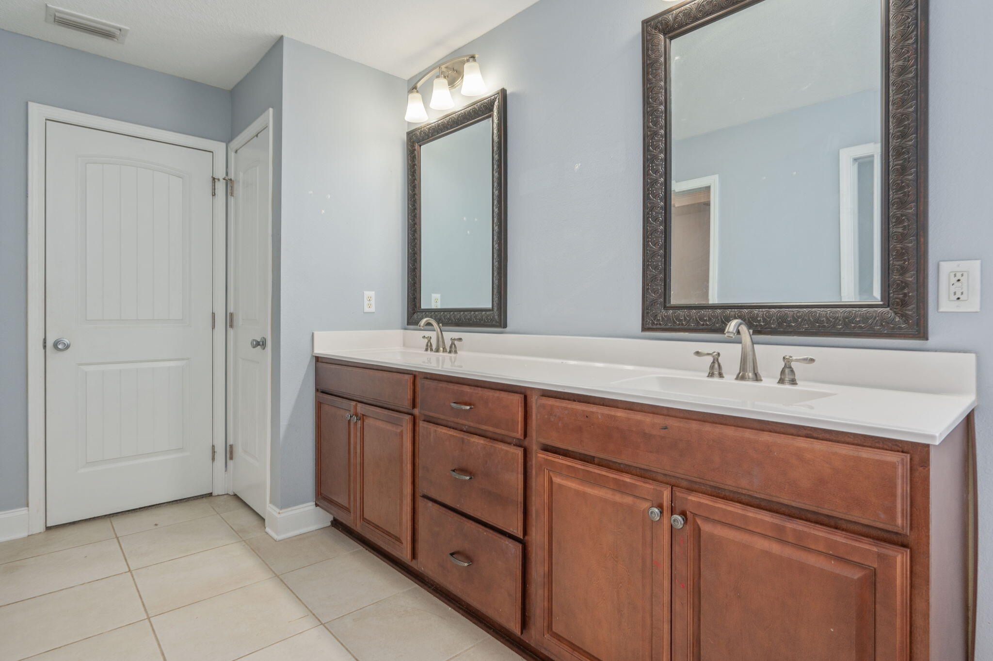2909 Chancery Lane Crestview, FL 32539 - Photo 16 of 34 a bathroom with a double vanity sink and a mirror