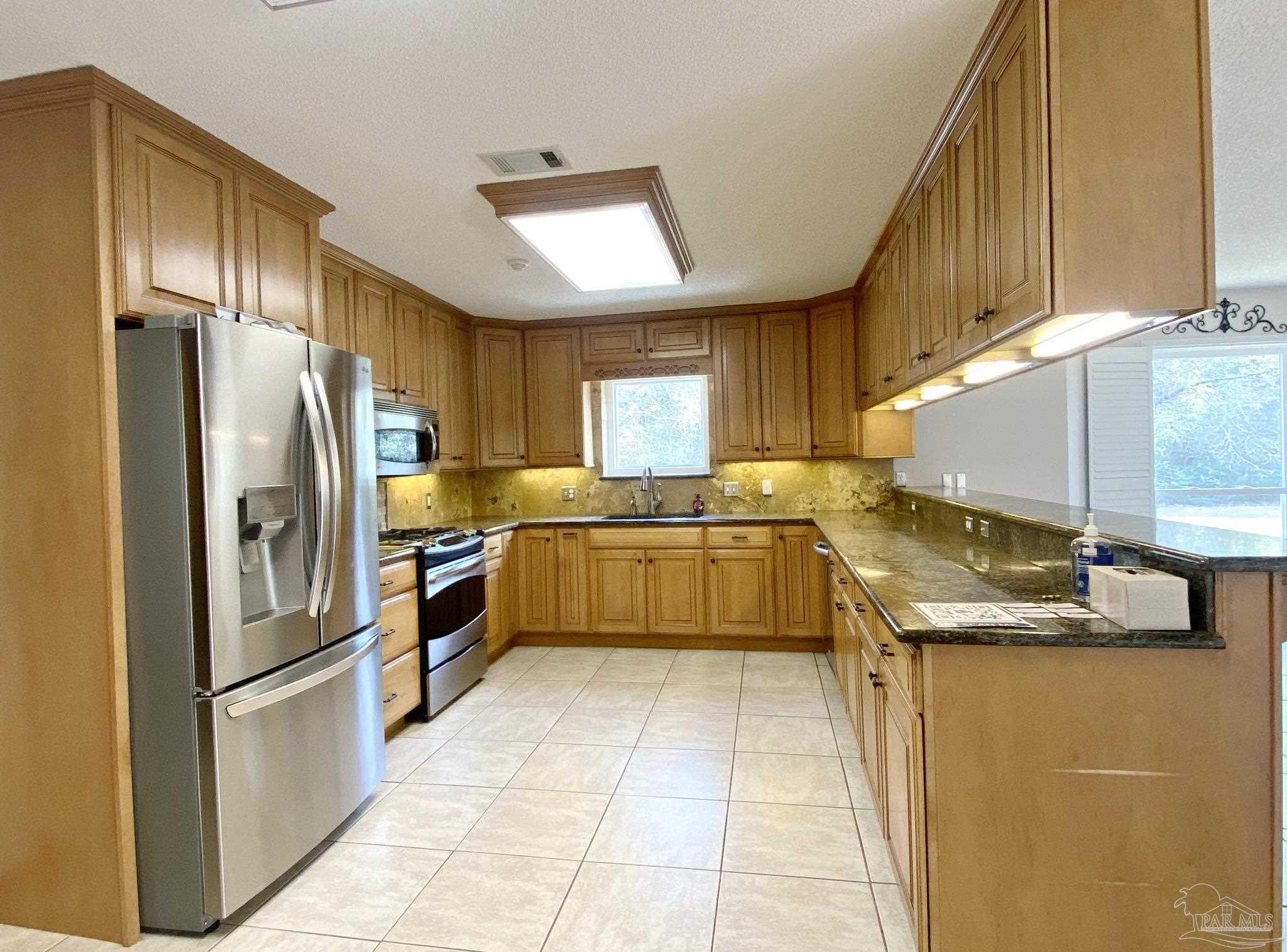 9141 Frank Pitman Road Milton, FL 32570 - Photo 26 of 51 a kitchen with granite countertop a sink stainless steel appliances and cabinets