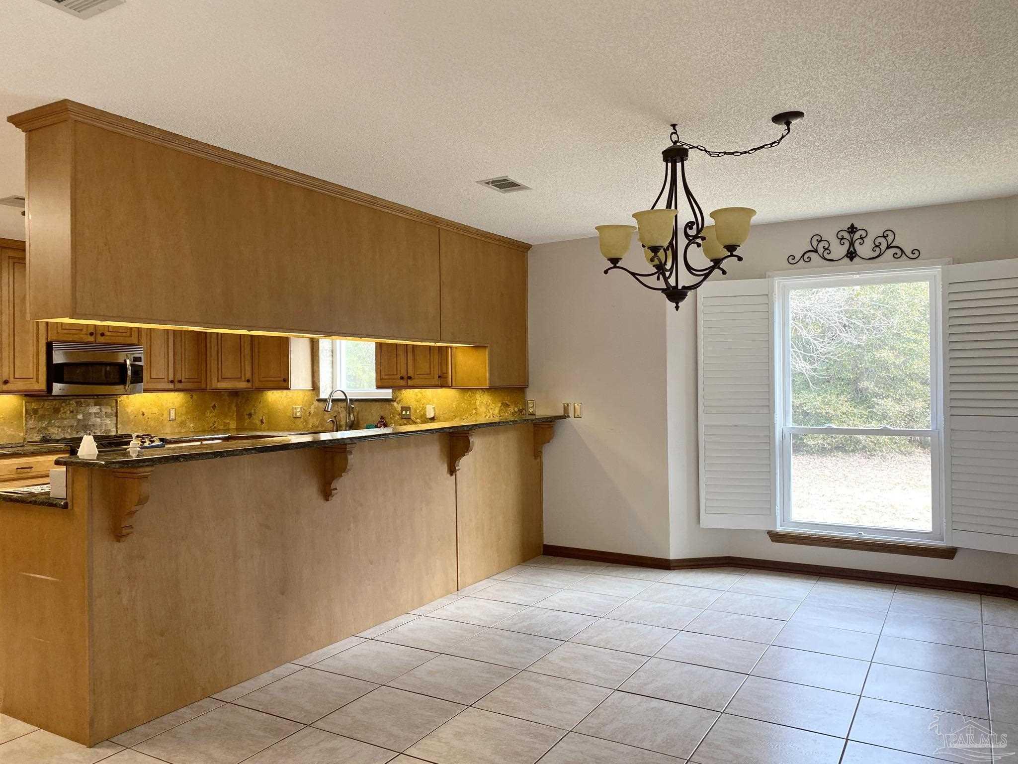 9141 Frank Pitman Road Milton, FL 32570 - Photo 28 of 51 a view of a room with a window and chandelier