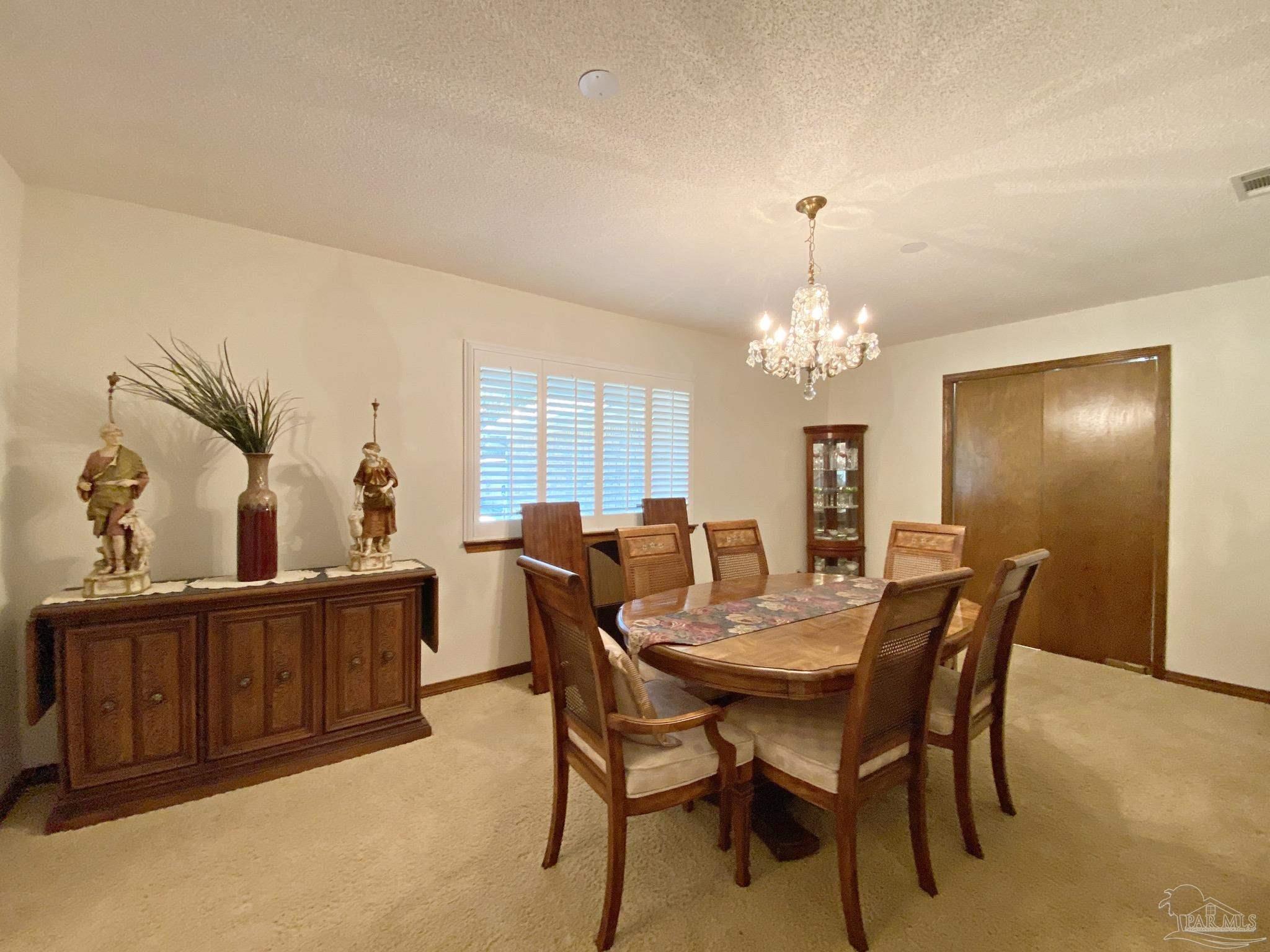 9141 Frank Pitman Road Milton, FL 32570 - Photo 29 of 51 a view of a dining room with furniture and chandelier