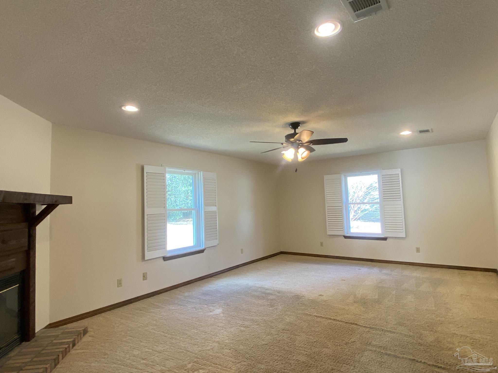 9141 Frank Pitman Road Milton, FL 32570 - Photo 33 of 51 an empty room with windows and ceiling fan
