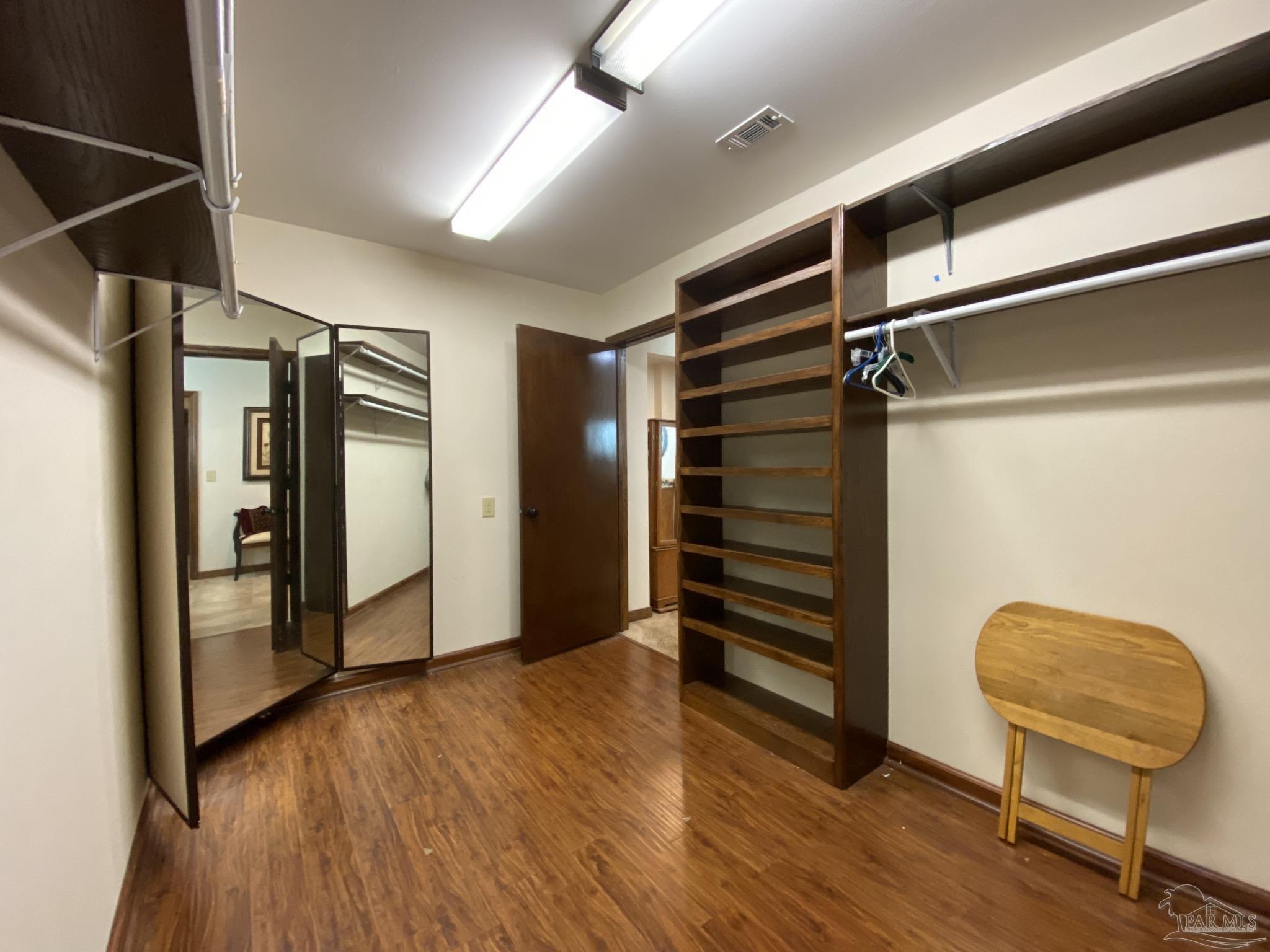 9141 Frank Pitman Road Milton, FL 32570 - Photo 39 of 51 a view of walk in closet with wooden floor