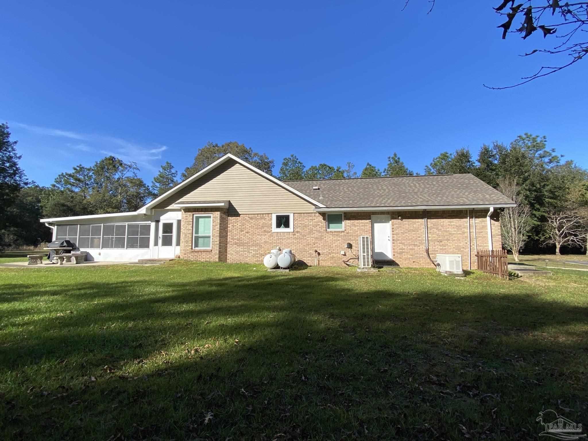 9141 Frank Pitman Road Milton, FL 32570 - Photo 9 of 51 a front view of a house with a yard table and chairs