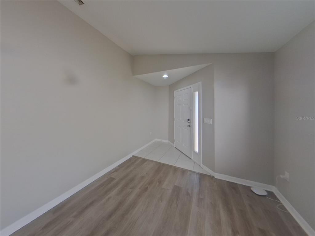 Undisclosed Address Ruskin, FL 33570 - Photo 4 of 16 a view of an empty room with wooden floor