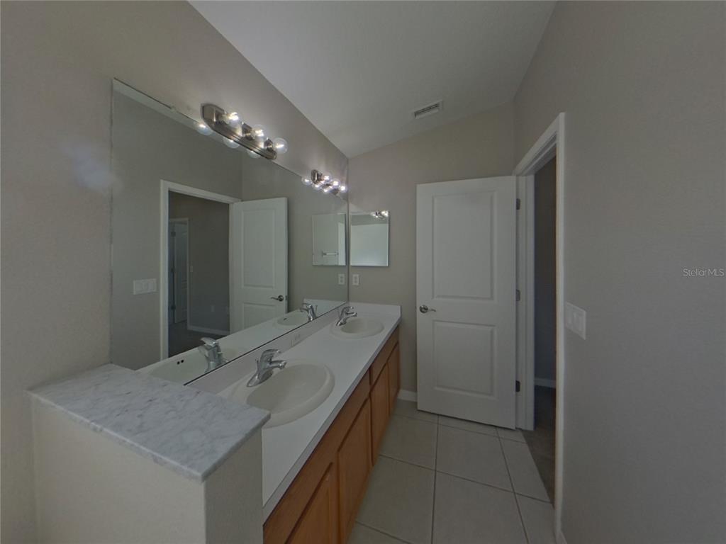 Undisclosed Address Ruskin, FL 33570 - Photo 10 of 16 a bathroom with a granite countertop sink a large mirror and a shower