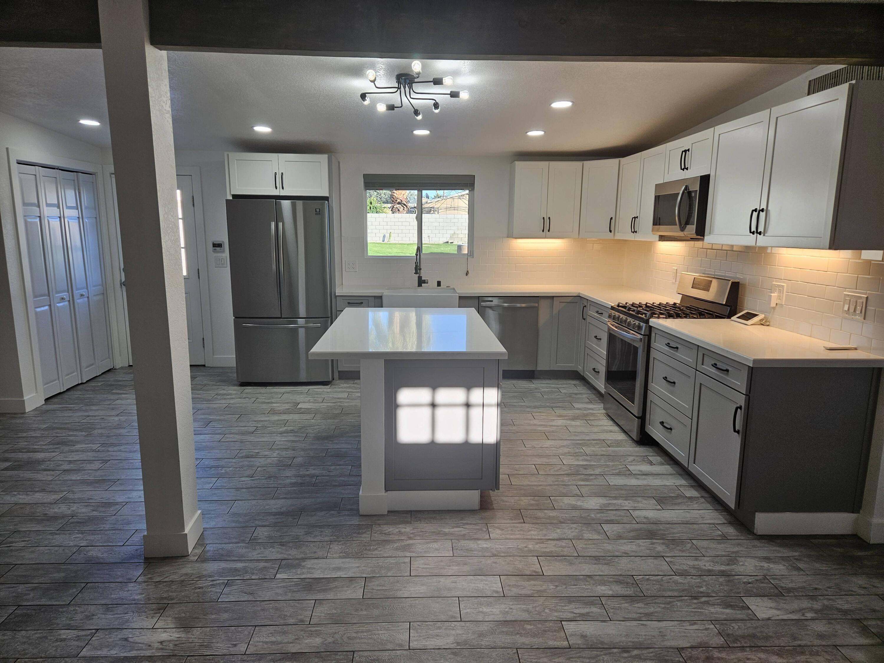 a large kitchen with kitchen island a stove a sink dishwasher and a refrigerator