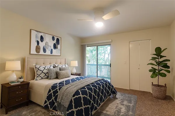 a bedroom with a large bed and a potted plant