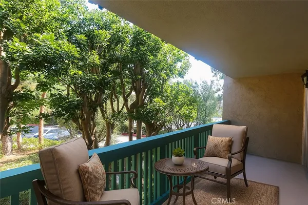 a balcony with wooden floor and outdoor seating