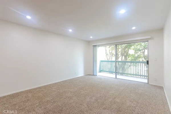 a view of an empty room with glass door and deck