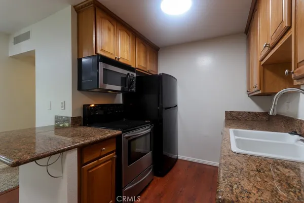 a kitchen with stainless steel appliances granite countertop a sink stove and refrigerator