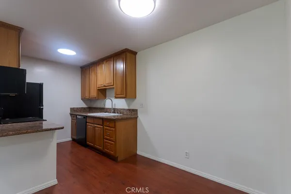 a kitchen with granite countertop a stove and a wooden floor