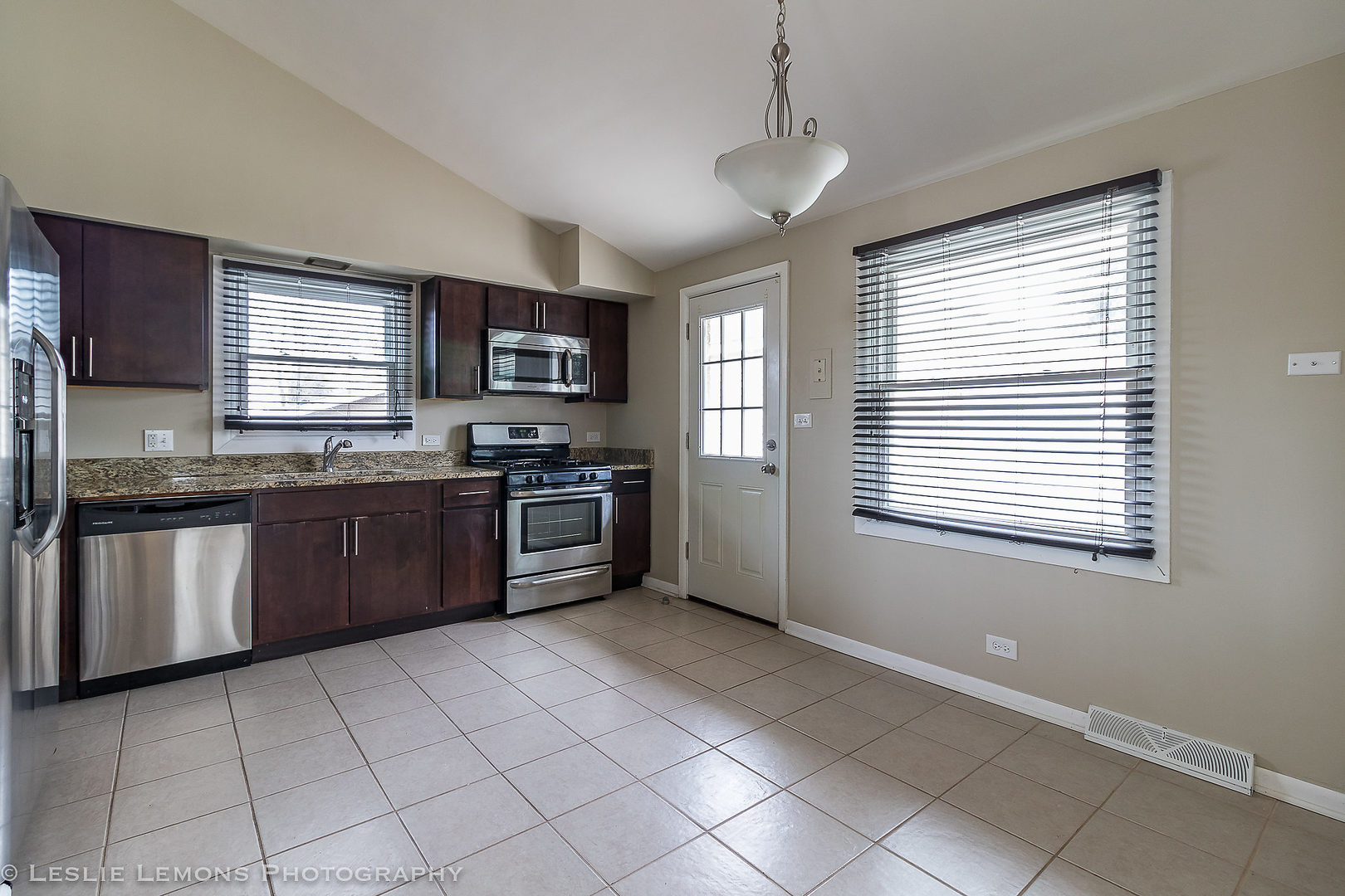 8541 North Shermer Road Niles, IL 60714 - Photo 7 of 26 a kitchen with stainless steel appliances granite countertop a stove sink and microwave