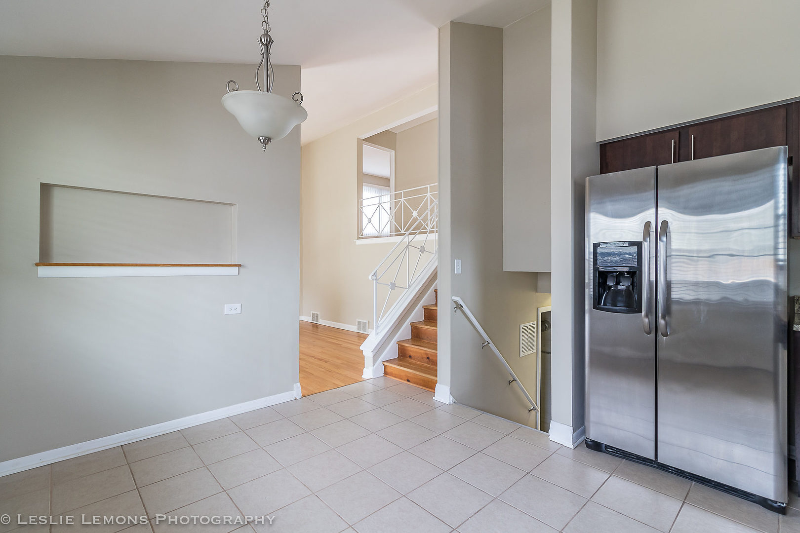 8541 North Shermer Road Niles, IL 60714 - Photo 8 of 26 a view of an empty room with wooden floor and a kitchen view