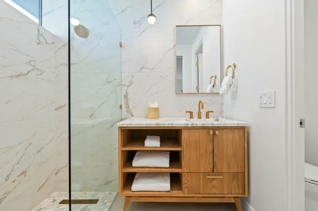 a spacious bathroom with a double vanity sink a mirror and a shower