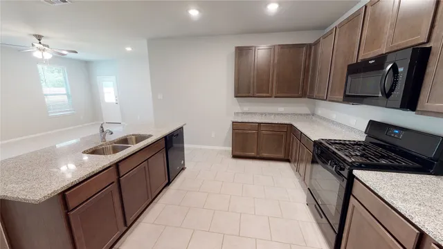 a kitchen with stainless steel appliances granite countertop a sink stove and cabinets