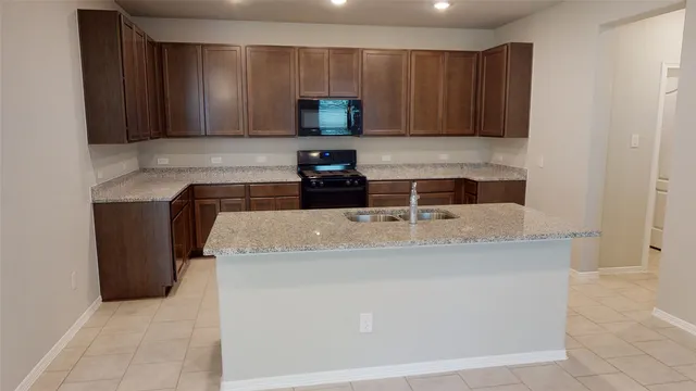 a kitchen with stainless steel appliances granite countertop a sink a stove and a microwave