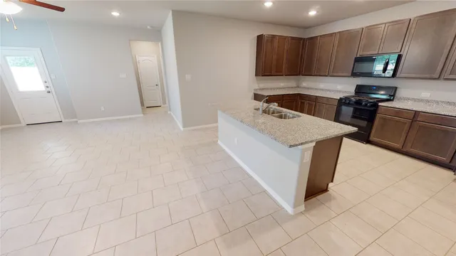 a kitchen with a sink a stove top oven and cabinetry