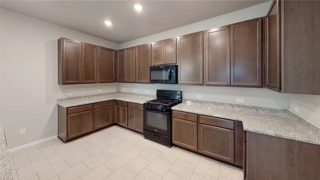 a kitchen with granite countertop wooden cabinets and stainless steel appliances