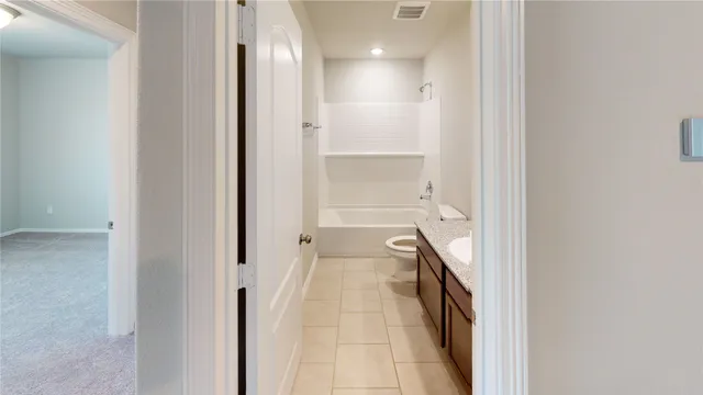 a hallway with a sink and a bathroom