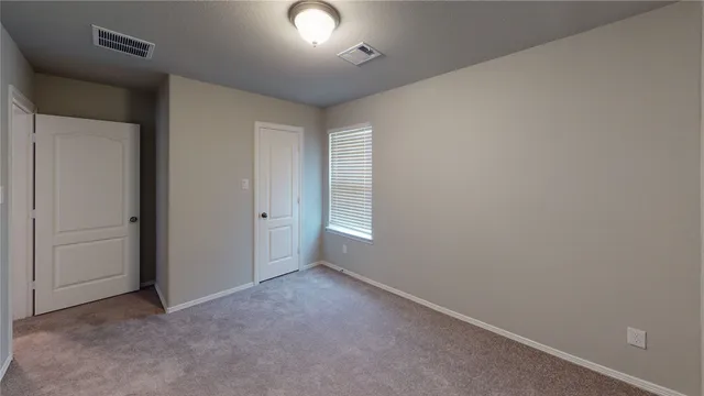 an empty room with windows and closet