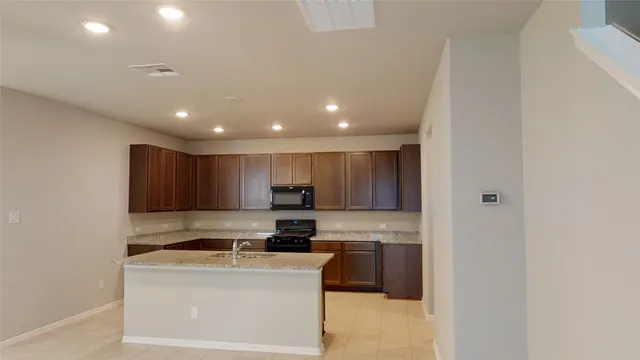 a kitchen with a refrigerator a stove top oven and a sink with wooden floor