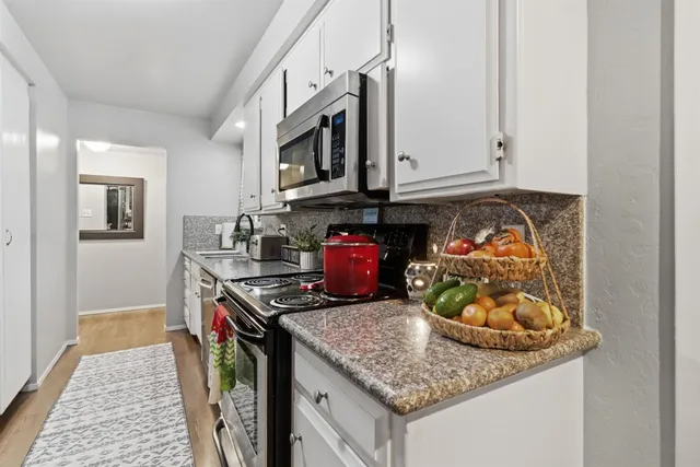 a kitchen with stainless steel appliances granite countertop a sink stove and microwave