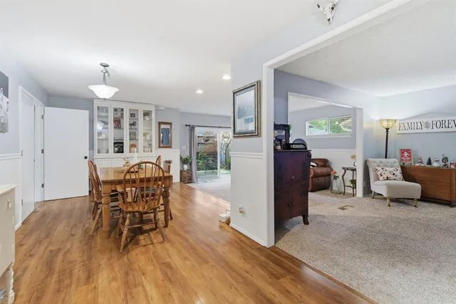 a dining room with furniture a chandelier and wooden floor