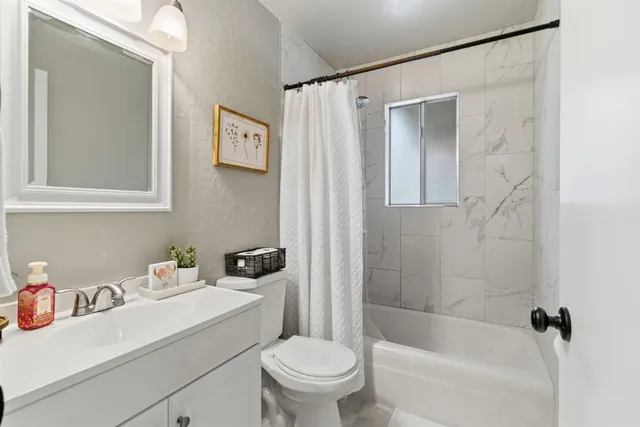 a spacious bedroom with a bed and a chandelier