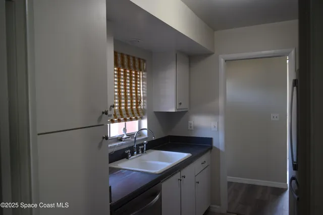a kitchen with a sink cabinets and a window