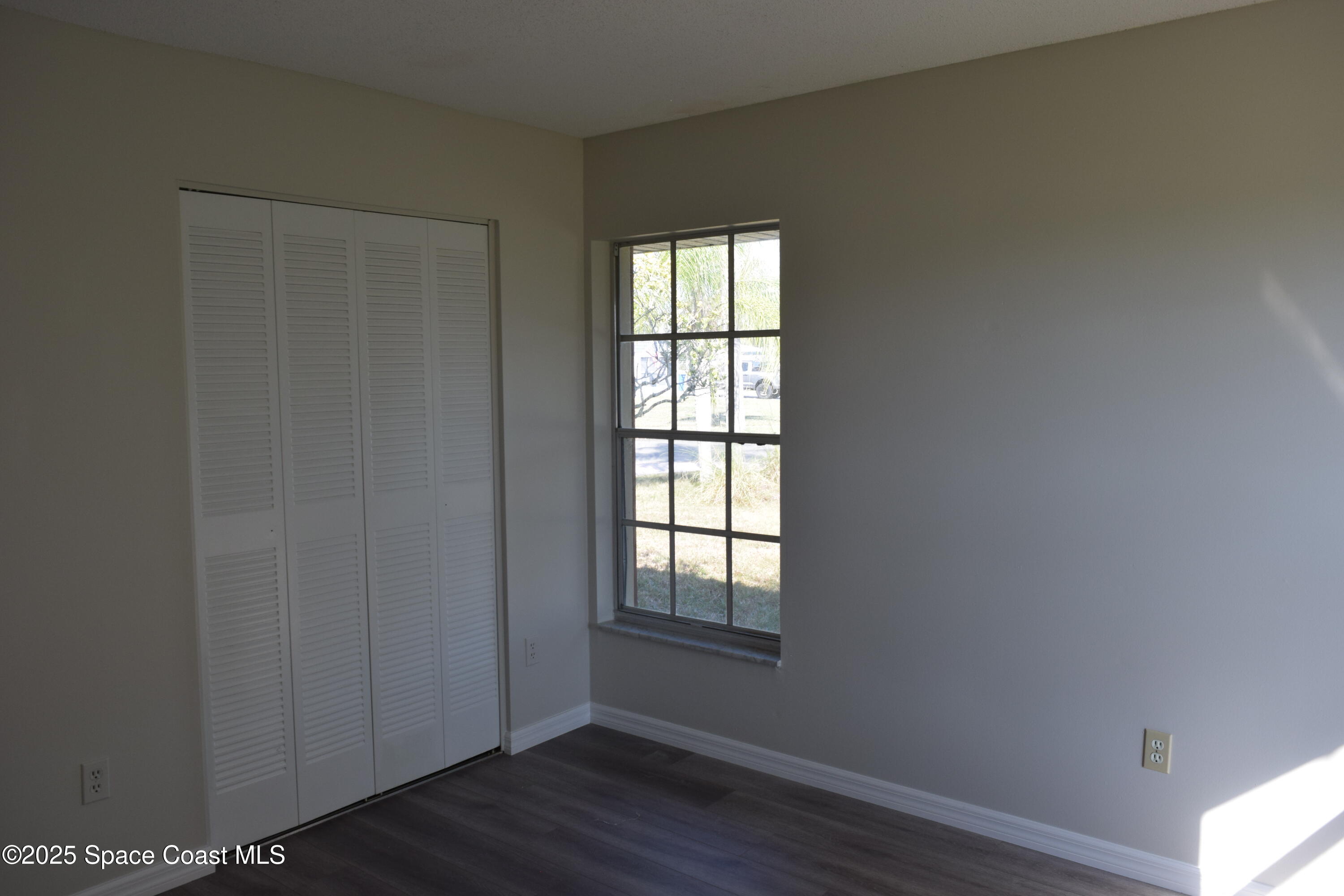 2696 Yalta Street Northeast Palm Bay, FL 32905 - Photo 21 of 28 a view of an empty room with wooden floor and a window