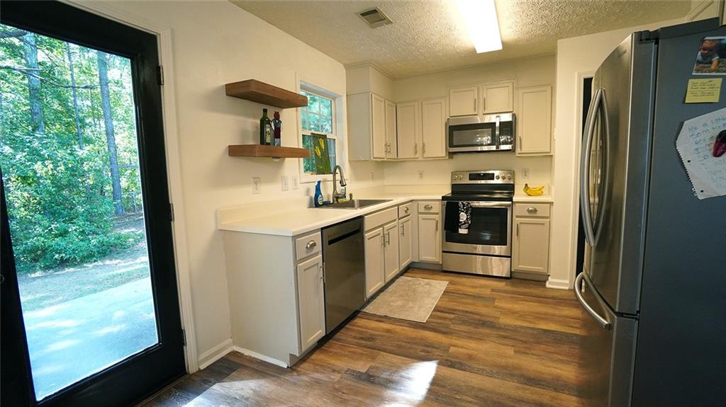 138 West Fork Way Temple, GA 30179 - Photo 3 of 21 a kitchen with stainless steel appliances granite countertop a refrigerator a sink a stove a washer dryer and white cabinets