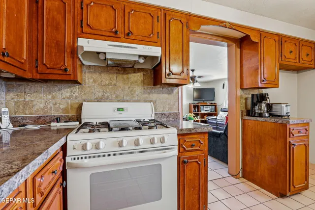 a kitchen with stainless steel appliances granite countertop a sink a stove and cabinets
